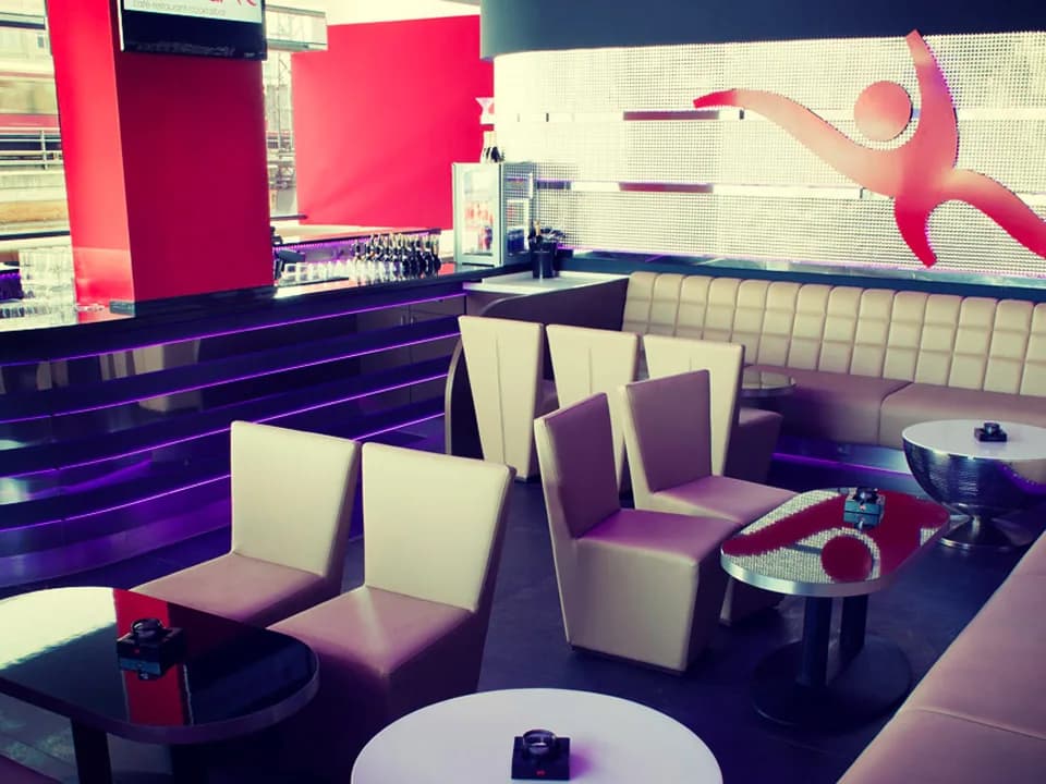 Sessel und Polsterbank in der Club-Lounge der Carambar, an der Wand die rote Carambar-Figur