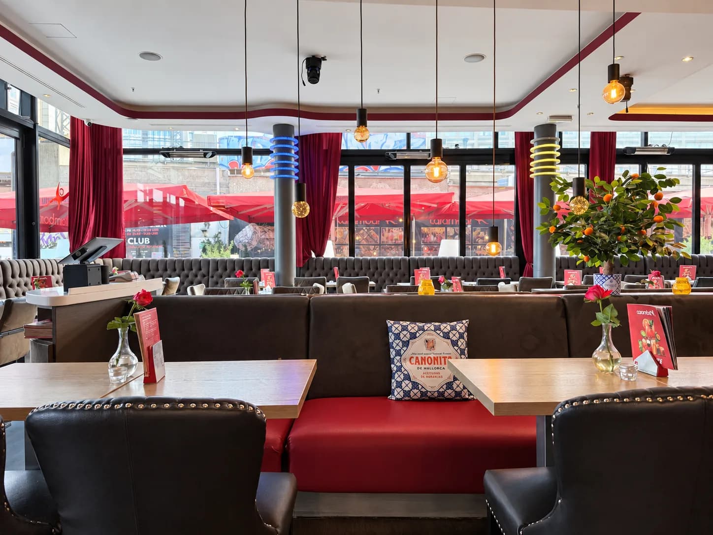 Sitznischen mit roten Polstern im Restaurant der Carambar, dahinter die Fensterfront